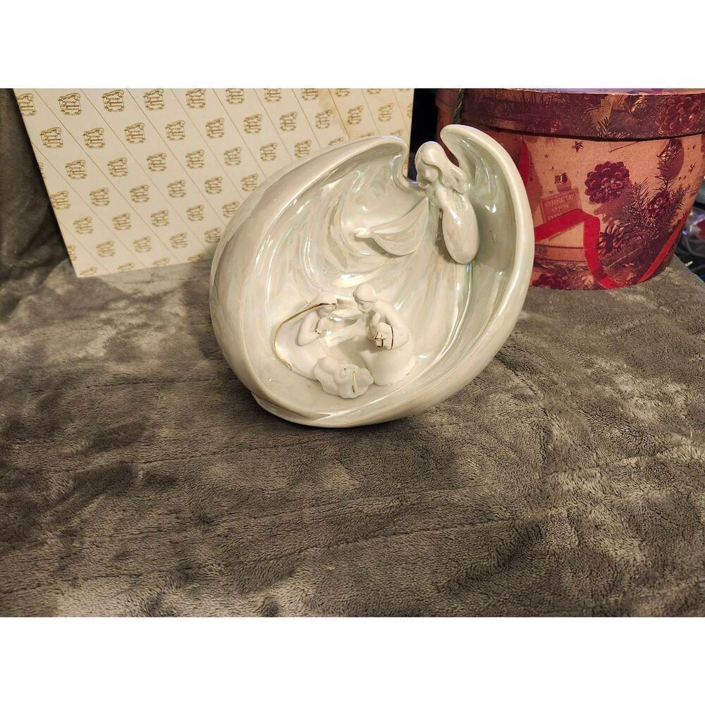 porcelain nativity scene figurine featuring an angel wrapping its wings around t